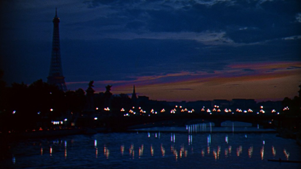 A scenic view of the Eiffel Tower at dusk, illuminated against a darkening sky, reflecting in the Seine River below, with city lights glimmering on the water.