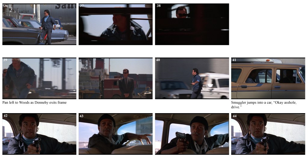 A man in a blue jacket standing near parked cars by a train.