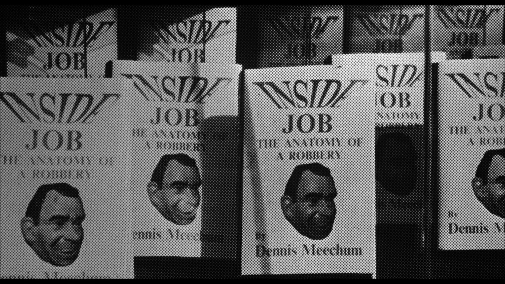 A stack of book covers titled 'Inside Job: The Anatomy of a Robbery' by Dennis Meechan, featuring a stylized illustration of a man's face.
