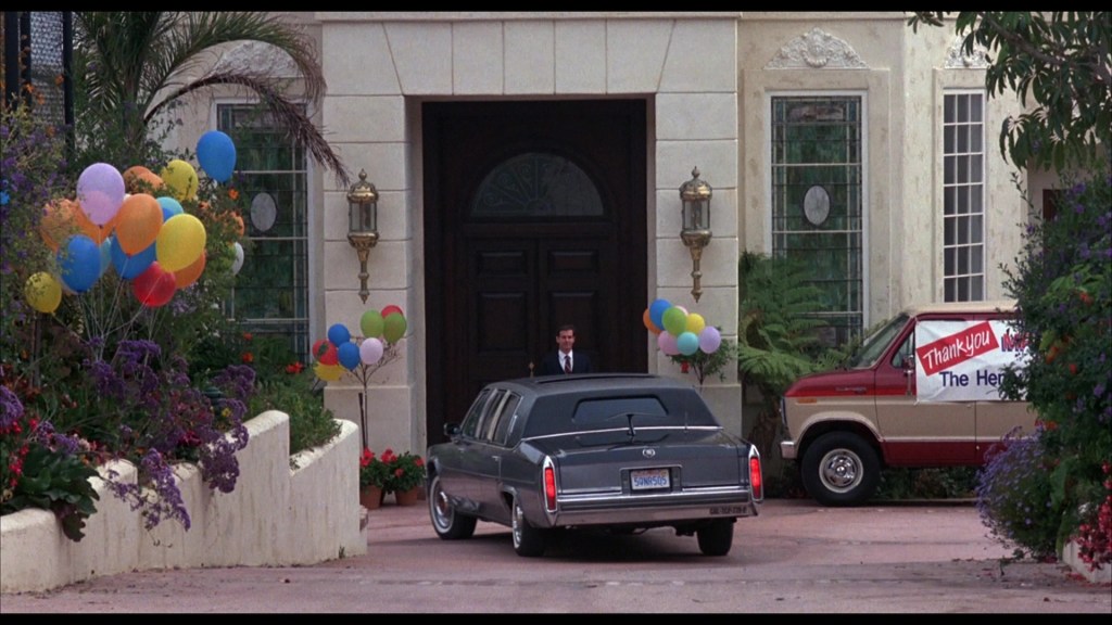 A large house entrance with a man standing outside, colorful balloons are displayed around, and a van with a sign saying 'Thank You' is parked nearby.
