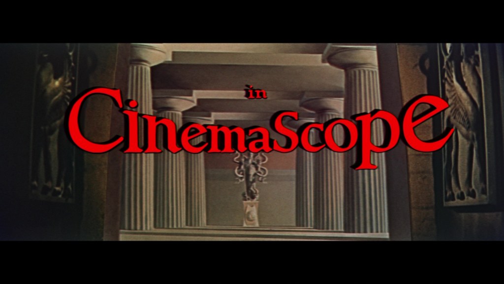 Text graphic displaying 'in Cinemascope' with a classical architectural background featuring columns and wall art.