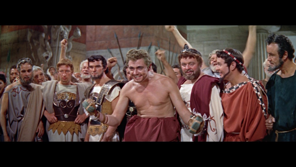 A group of ancient Roman men in togas and armor, celebrating enthusiastically in a grand hall, with one man in the center holding a trophy and smiling.