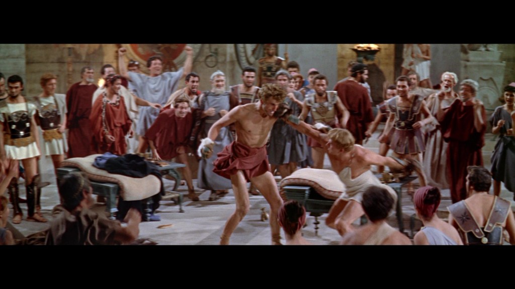 A dramatic scene depicting a gladiatorial fight in a Roman arena, with a crowd of spectators cheering in the background.