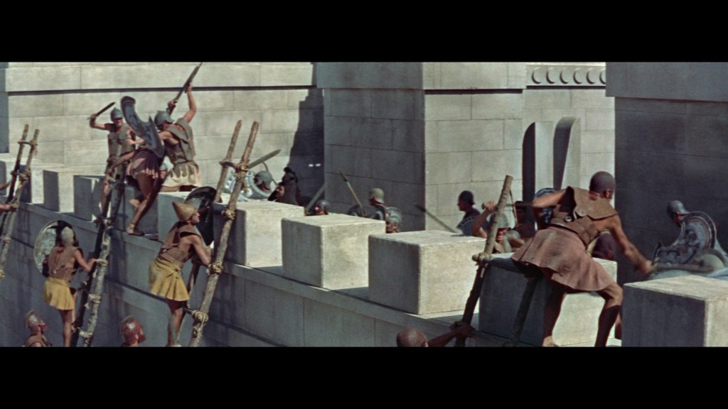 A group of ancient warriors climbing a fortified wall using ladders, engaged in a battle scene.