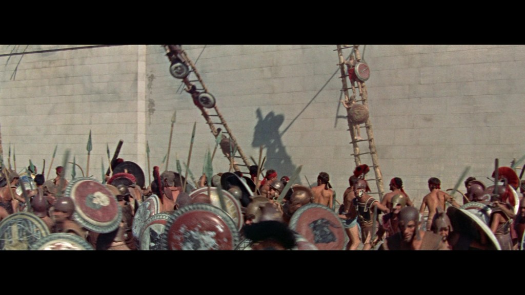 A scene depicting a battle with ancient soldiers, armed with shields and spears, preparing to scale a wall using ladders.