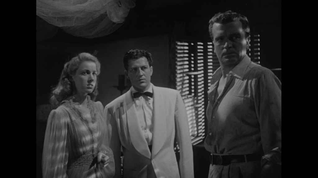 Three characters in a dramatic, shadowy setting, one woman with blonde hair in a white dress, a man in a white suit, and another man in a gray shirt, all looking concerned.