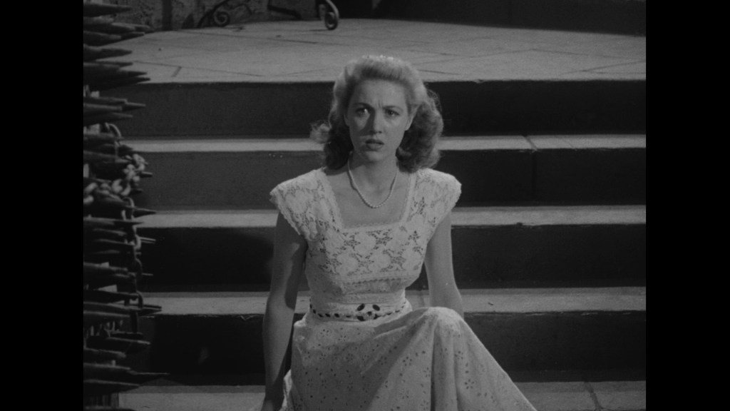 A woman in a vintage white dress sits on stairs, looking concerned or anxious.